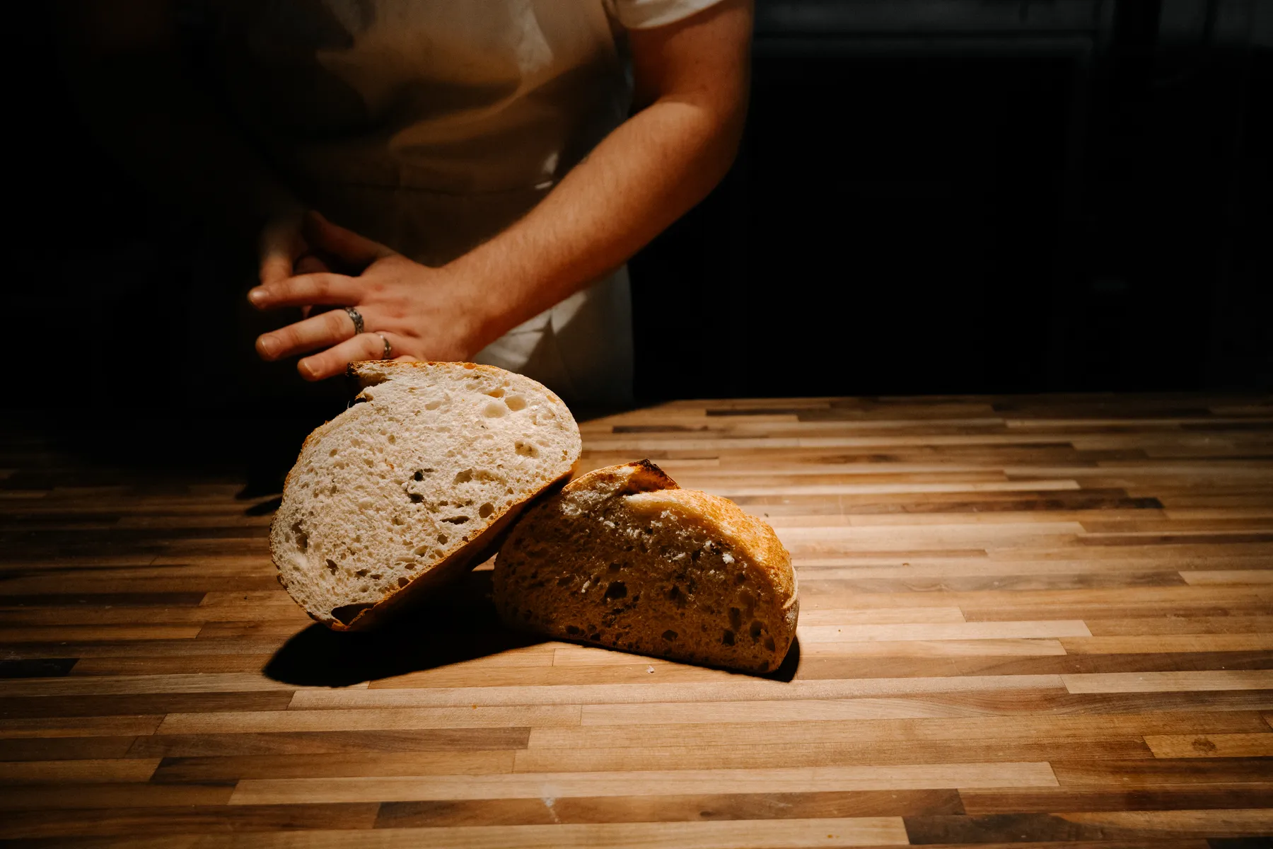 Freshly baked sourdough loaves cooling on a wooden rack